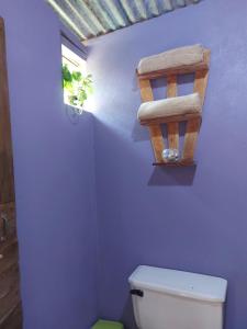 a bathroom with a toilet and a plant on the wall at Anez Cabin'S in Cabuya