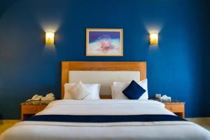 a bedroom with a large bed with blue walls at Tropitel Dahab Oasis in Dahab
