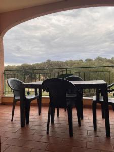 a patio with chairs and tables on a balcony at CASA GIULIA - Holiday Home in Olbia