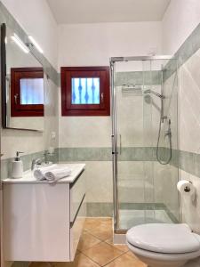 a bathroom with a shower and a toilet and a sink at CASA GIULIA - Holiday Home in Olbia +8 photos