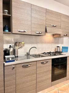 a kitchen with wooden cabinets and a sink at CASA GIULIA - Holiday Home in Olbia