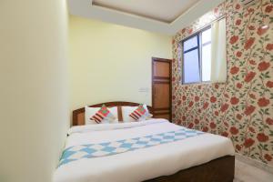- une chambre avec un grand lit et une fenêtre dans l'établissement OYO Home Cozy Studio Collage Square Hotel Maya International Near St. Thomas's Church, à Kolkata