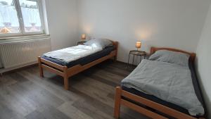 GrafrathにあるBei München Ferienwohnung in Grafrath Amperschluchtのベッドルーム1室(ツインベッド2台、ランプ2つ付)