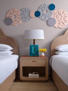 una camera con due letti e un tavolo con una lampada di Marriott Hutchinson Island Beach Resort, Golf & Marina a Stuart