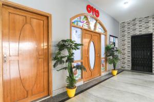 a wooden door with two plants in front of it at Super OYO Capital O 78105 Hotel Figtree Premier in Patna
