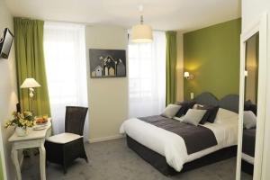 a bedroom with a bed and a table and a chair at Hôtel Restaurant Corto Maltese in Le Palais