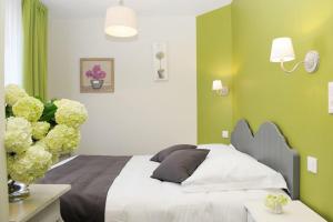 a bedroom with a bed with green walls and flowers at Hôtel Restaurant Corto Maltese in Le Palais
