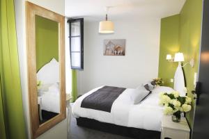 a hotel room with a bed and a mirror at Hôtel Restaurant Corto Maltese in Le Palais
