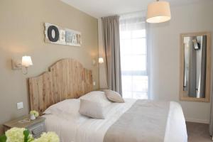 a bedroom with a large white bed and a window at Hôtel Restaurant Corto Maltese in Le Palais