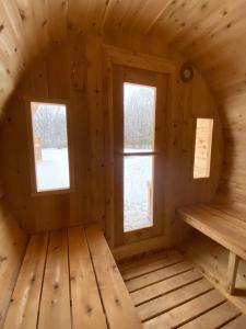 um quarto num chalé de madeira com duas janelas em Kings Woods Lodge Resort in Wine Country with Heated Pool, Sauna & Games em Kingsville