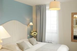 a bedroom with a white bed and a window at Hôtel Restaurant Corto Maltese in Le Palais