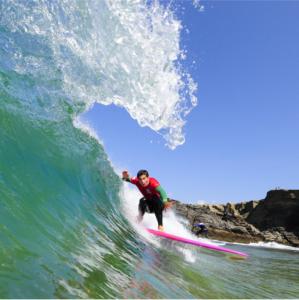 a man riding a wave on a surfboard in the ocean at Hôtel Restaurant Corto Maltese in Le Palais