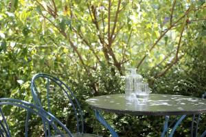 una mesa con una botella de cristal encima en Appartement avec terrasse en pleine nature, en Ougney-Douvot