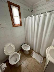 een badkamer met 2 toiletten en een douchegordijn bij Verona Cabaña in Necochea +5 foto's