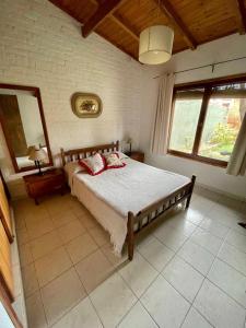 een slaapkamer met een bed, een spiegel en ramen bij Verona Cabaña in Necochea