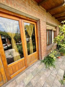 een stenen huis met een houten deur met ramen bij Verona Cabaña in Necochea