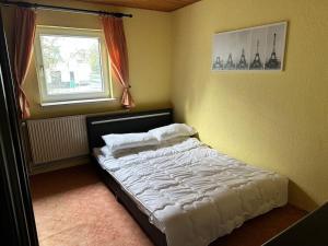 a bed in a bedroom with a window at Haus im Grünen 1.700m Grundstück in Chemnitz