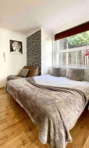 una camera con un grande letto e una finestra di A beautiful studio flat with garden a Londra