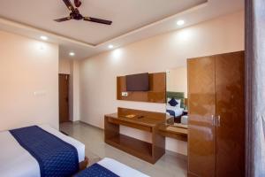 a bedroom with a bed and a desk with a tv at Hotel Katra Hills in Katra
