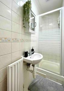 a white bathroom with a sink and a shower at A beautiful studio flat with garden in London