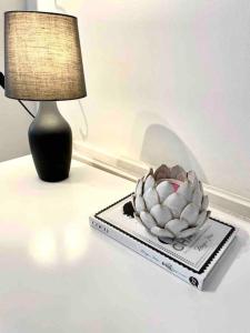 una lampada e una ciotola sopra un tavolo di A beautiful studio flat with garden a Londra