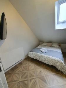 een kleine slaapkamer met een bed en een raam bij The Wine House 21 in Dijon