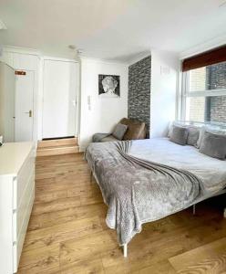a bedroom with a bed and a chair in it at A beautiful studio flat with garden in London