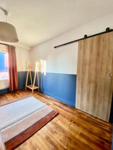 a room with a bed and a wooden door at Charmant gîte au bord de la Sarthe - 3 chambres - 6 personnes in Fillé