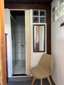 a bathroom with a chair and a shower at Pousada Sambaki in Paraty