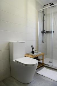 een witte badkamer met een toilet en een douche bij Boutique Wine Hotel Panorama in Macedo de Cavaleiros