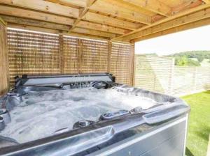 a large hot tub sitting on top of a patio at Pen-y-Coed ⥈ Modern ⥈ Hot Tub ⥈ Beautiful Views in Abergele