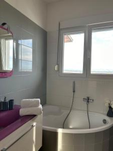 a white bathroom with a tub and two windows at Sunrise Villa in Kassandria