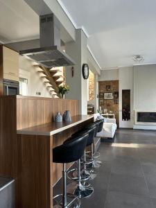 a kitchen with a bar with black stools at Sunrise Villa in Kassandra