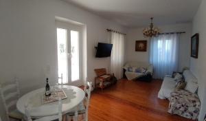 a living room with a white table and a couch at Casa Sulla Montagna in Loutses