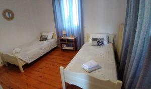 a room with two beds and a table with a window at Casa Sulla Montagna in Loutses