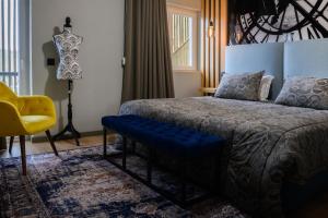 een slaapkamer met een bed en een gele stoel bij Boutique Wine Hotel Panorama in Macedo de Cavaleiros