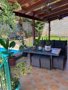 eine Terrasse mit einem Tisch und Stühlen unter einer Pergola in der Unterkunft Casa con Gran Piscina en Ciudad de los Valles in Santiago