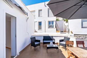 a patio with chairs and a table and an umbrella at Apartamentos Dulcemar Frente al Mar con zona SPA in San José