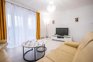 sala de estar con sofá, TV y mesa en Targowa 41, en Toruń