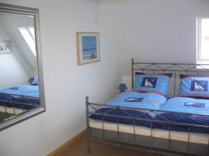 um quarto com uma cama com almofadas azuis e um espelho em Lichtis Hues em List