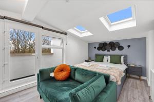 um quarto com um sofá verde e uma cama em Hilldrop Apartments em Londres