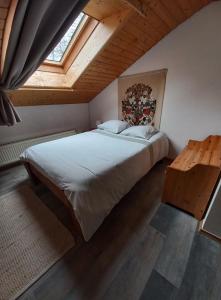 ein Schlafzimmer mit einem großen Bett und einer Holzdecke in der Unterkunft Le Grand Chalet in La Chapelle