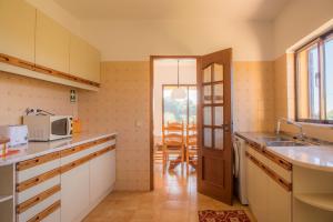 een keuken met een wastafel en een deur naar een patio bij D05 - Amadeus Sunset Villa in Mato Porcas