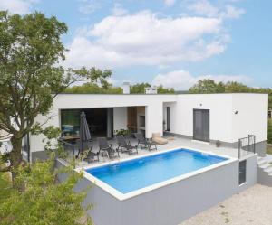 a white house with a swimming pool in the backyard at Traumhafte Villa Dubi bei Labin in Labin