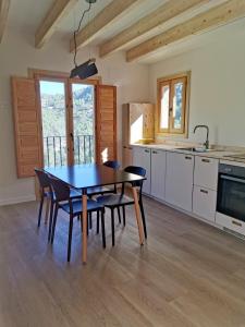 a kitchen and dining room with a table and chairs at Cara Norte , Casa Rural-Castillo de Villamalefa in Castillo de Villamalefa