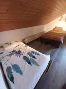 ein Schlafzimmer mit einem Bett mit einer Bettdecke darauf in der Unterkunft Le Grand Chalet in La Chapelle