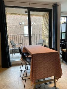 einen Tisch und Stühle in einem Zimmer mit Balkon in der Unterkunft Central Studio in Kortrijk in Kortrijk