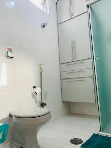 uma casa de banho com um WC e uma cabina de duche em vidro. em Felicitatem Apartments Higienópolis - Apartamento Compartilhado em São Paulo