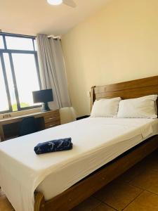Felicitatem Apartments Higienópolis - Apartamento Compartilhado في ساو باولو: غرفة نوم عليها سرير مع حقيبة زرقاء