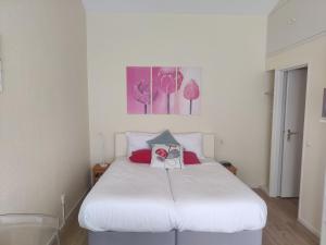 um quarto com uma cama branca com duas almofadas em B&B De Slaperije em Warnsveld